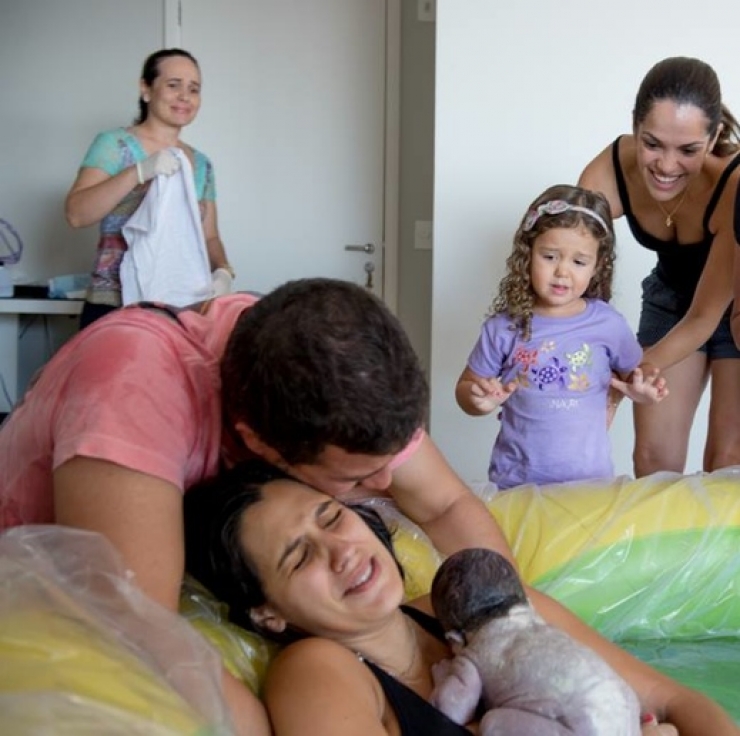 fotoserie bevalling thuis in waterbad met hele gezin
